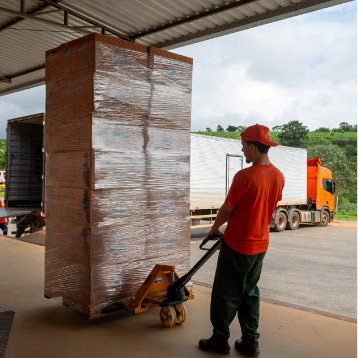 Colaborador carregando pallet no centro de distribuição
